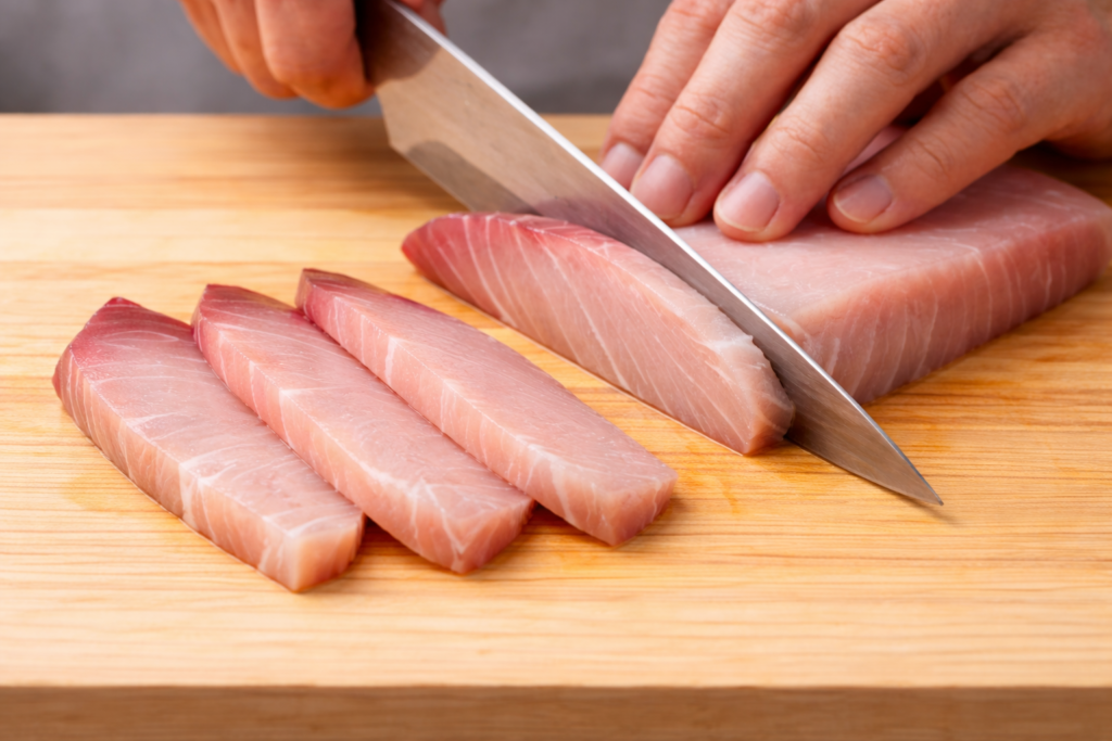 手巻き寿司の刺身の切り方｜ハマチの刺身を斜めに切って長さを出している様子